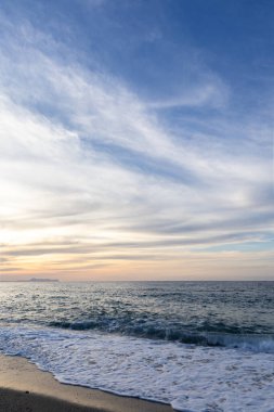 Gün batımında kumlu ve çakıl taşı plajı olan güzel bir sahil şeridi. Platanes Beach, Rethymno, Girit, Yunanistan 'ın turizm ve otel bölgesinde güzel gökyüzü renklendirmesi