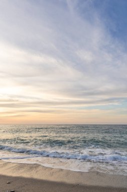 Gün batımında kumlu ve çakıl taşı plajı olan güzel bir sahil şeridi. Platanes Beach, Rethymno, Girit, Yunanistan 'ın turizm ve otel bölgesinde güzel gökyüzü renklendirmesi
