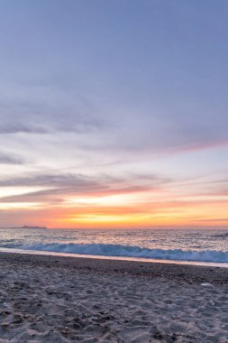Gün batımında kumlu ve çakıl taşı plajı olan güzel bir sahil şeridi. Platanes Beach, Rethymno, Girit, Yunanistan 'ın turizm ve otel bölgesinde güzel gökyüzü renklendirmesi
