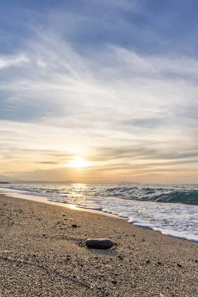 Gün batımında kumlu ve çakıl taşı plajı olan güzel bir sahil şeridi. Platanes Beach, Rethymno, Girit, Yunanistan 'ın turizm ve otel bölgesinde güzel gökyüzü renklendirmesi
