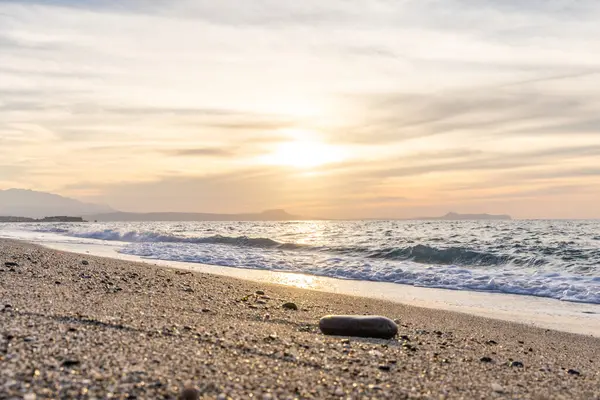 Gün batımında kumlu ve çakıl taşı plajı olan güzel bir sahil şeridi. Platanes Beach, Rethymno, Girit, Yunanistan 'ın turizm ve otel bölgesinde güzel gökyüzü renklendirmesi