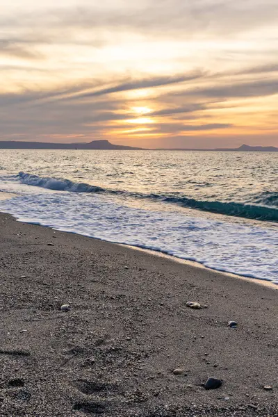 Gün batımında kumlu ve çakıl taşı plajı olan güzel bir sahil şeridi. Platanes Beach, Rethymno, Girit, Yunanistan 'ın turizm ve otel bölgesinde güzel gökyüzü renklendirmesi