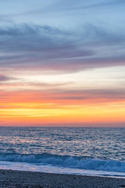 Gün batımında kumlu ve çakıl taşı plajı olan güzel bir sahil şeridi. Platanes Beach, Rethymno, Girit, Yunanistan 'ın turizm ve otel bölgesinde güzel gökyüzü renklendirmesi