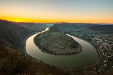 Moselle 'in üzerinde gün doğumu. Nehir, Bremm, Calmont, Rhineland-Palatinate, Almanya yakınlarındaki üzüm bağlarıyla çevrili dar bir döngü içinde bir vadiden geçiyor.