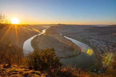 Moselle 'in üzerinde gün doğumu. Nehir, Bremm, Calmont, Rhineland-Palatinate, Almanya yakınlarındaki üzüm bağlarıyla çevrili dar bir döngü içinde bir vadiden geçiyor.