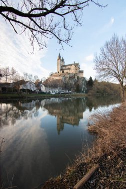 Gün doğumunda çekilmiş bir kış manzarası. Bir sürü doğa ve kayanın üzerinde büyük bir kilise var. St. Lubentius Limburger eski kolej kilisesi, Dietkirchen, Hesse