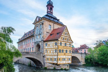 Nehir kenarındaki bir kasabanın manzara fotoğrafı. Köprüdeki tarihi bir binanın görüntüsü. Sabahları yarı keresteli ev ve belediye binası. Bamberg, Bavyera, Almanya 'da Doğa