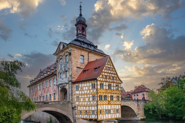 Nehir kenarındaki bir kasabanın manzara fotoğrafı. Köprüdeki tarihi bir binanın görüntüsü. Sabahları yarı keresteli ev ve belediye binası. Bamberg, Bavyera, Almanya 'da Doğa
