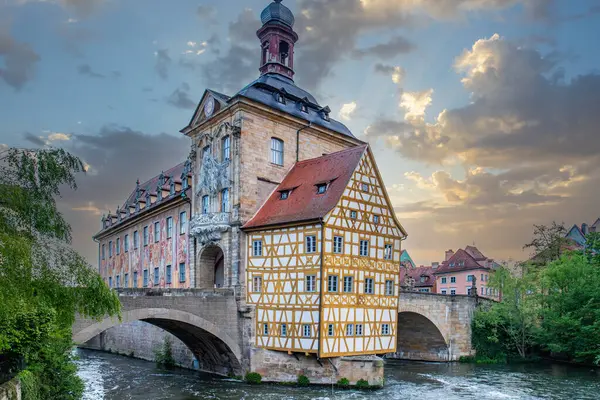 Nehir kenarındaki bir kasabanın manzara fotoğrafı. Köprüdeki tarihi bir binanın görüntüsü. Sabahları yarı keresteli ev ve belediye binası. Bamberg, Bavyera, Almanya 'da Doğa
