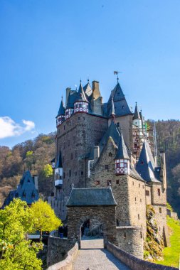 Vadideki kale yeşil bir kayın ormanıyla çevrili. Sabah güneş doğarken çekilmiş. Eltz Nehri üzerinde güzel manzara fotoğrafı, Eltz Şatosu, Almanya