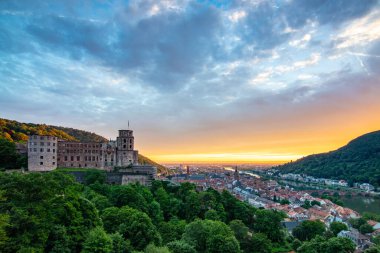 Kale harabeleri olan eski bir kasabanın tepesinden manzara. Almanya, Heidelberg 'de gün batımında manzara