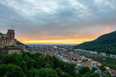 Kale harabeleri olan eski bir kasabanın tepesinden manzara. Almanya, Heidelberg 'de gün batımında manzara