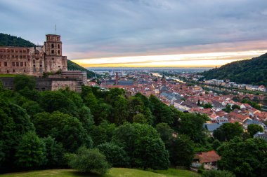 Kale harabeleri olan eski bir kasabanın tepesinden manzara. Almanya, Heidelberg 'de gün batımında manzara
