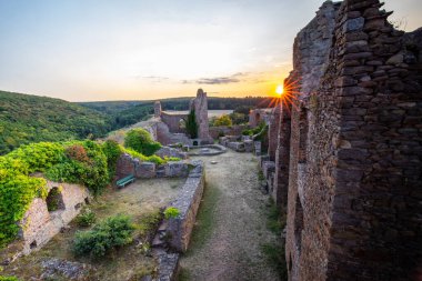Şato harabelerinin üzerinde gün batımı, Almanya 'nın Palatinate Ormanı' ndaki yazdan kalma güzel manzara fotoğrafı.