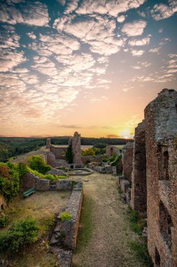 Şato harabelerinin üzerinde gün batımı, Almanya 'nın Palatinate Ormanı' ndaki yazdan kalma güzel manzara fotoğrafı.