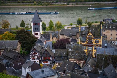 Eski, ahşap bir kasabaya bakın. Ren nehri boyunca çekilen bulutlu bir manzara. Alman Şarap Yolu, Bacharach, Almanya