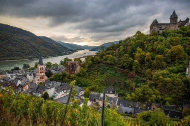 Eski, ahşap bir kasabaya bakın. Ren nehri boyunca çekilen bulutlu bir manzara. Alman Şarap Yolu, Bacharach, Almanya