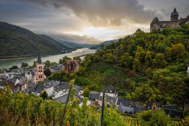 Eski, ahşap bir kasabaya bakın. Ren nehri boyunca çekilen bulutlu bir manzara. Alman Şarap Yolu, Bacharach, Almanya