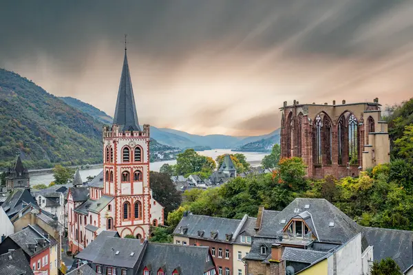 Eski, ahşap bir kasabaya bakın. Ren nehri boyunca çekilen bulutlu bir manzara. Alman Şarap Yolu, Bacharach, Almanya