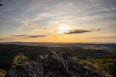 Taunus, Almanya 'da Feldberg' de güzel bir günbatımı. Doğada harika bir manzarayla ön planda bir taş ve yeşillik fotoğrafı çekildi.