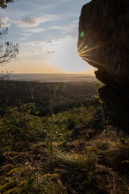 Taunus, Almanya 'da Feldberg' de güzel bir günbatımı. Doğada harika bir manzarayla ön planda bir taş ve yeşillik fotoğrafı çekildi.