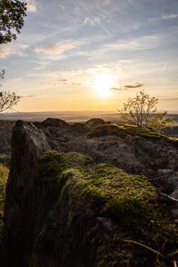 Taunus, Almanya 'da Feldberg' de güzel bir günbatımı. Doğada harika bir manzarayla ön planda bir taş ve yeşillik fotoğrafı çekildi.