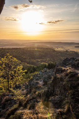 Taunus, Almanya 'da Feldberg' de güzel bir günbatımı. Doğada harika bir manzarayla ön planda bir taş ve yeşillik fotoğrafı çekildi.