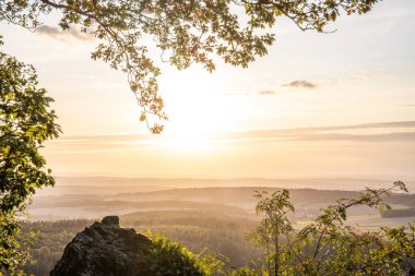 Taunus, Almanya 'da Feldberg' de güzel bir günbatımı. Doğada harika bir manzarayla ön planda bir taş ve yeşillik fotoğrafı çekildi.