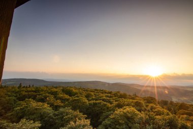 Taunus, Almanya 'da Feldberg' de güzel bir günbatımı. Doğada harika bir manzarayla ön planda bir taş ve yeşillik fotoğrafı çekildi.