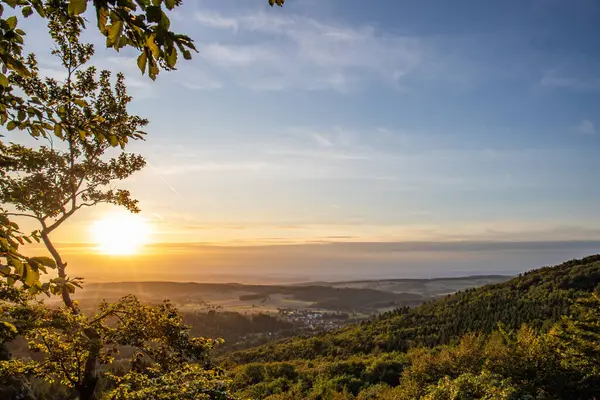 Taunus, Almanya 'da Feldberg' de güzel bir günbatımı. Doğada harika bir manzarayla ön planda bir taş ve yeşillik fotoğrafı çekildi.