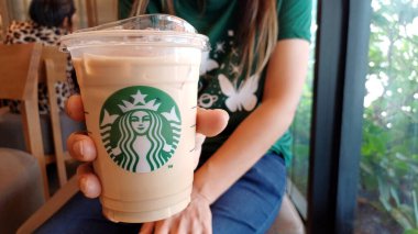 CHANTHABURI, THAILAND - 04 Nisan 2023: Central Chanthaburi alışveriş merkezinde kadının elinde Starbucks kahve fincanı