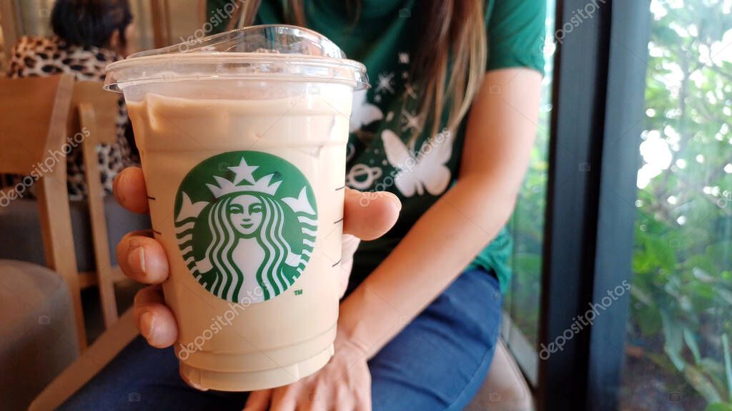 CHANTHABURI, THAILAND - 04 APRIL 2023: Starbucks Coffee cup in woman's hand at Central Chanthaburi shopping center