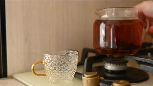 Газовой Плите Стеклянный Чайник Вареным Чаем Наливая Чай Стеклянную Чашку — стоковое видео
