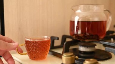 Gaz sobasında demlenmiş çaydanlık, demlenmiş çaydanlık, cam bardağa çay doldurmak. Yüksek kaliteli FullHD görüntüler