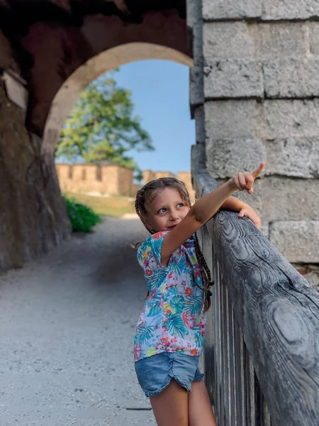 Avusturya 'daki dağdaki Ortaçağ şatosundaki kız. Çiçekler ve mimari. Avusturya 'nın resimli manzaraları.