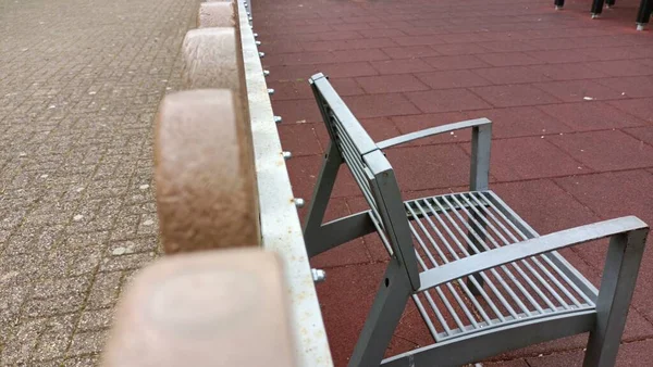 Iron bench on the playground near the fence made of plastic. High quality photo