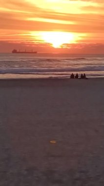 Several people watch a beautiful sunset on the ocean in Lisbon. High quality FullHD footage