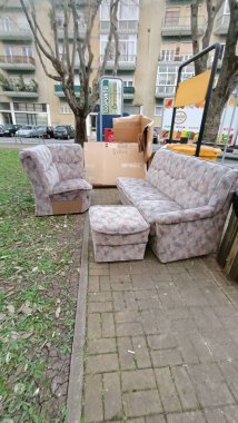 Çöp konteynırının yanındaki çöpe eski bir kanepe ve haçlar atıldı. Yüksek kalite fotoğraf