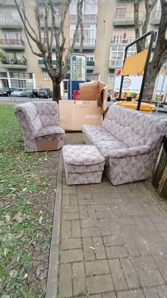 Çöp konteynırının yanındaki çöpe eski bir kanepe ve haçlar atıldı. Yüksek kalite fotoğraf