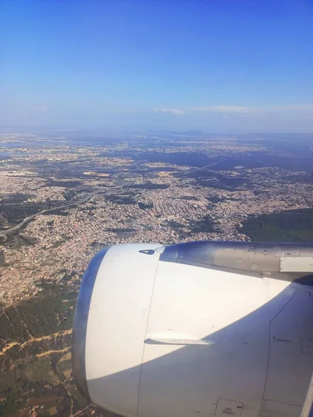 Uçağın penceresinden Lizbon ve Portekiz şehrine bakın. Açık mavi gökyüzü, uçak motoru ve kanadı. Yüksek kalite fotoğraf