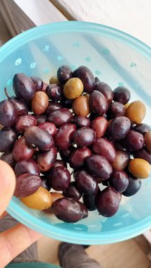 Plastik mavi bir kapta zeytin ve zeytin. Yüksek kalite fotoğraf