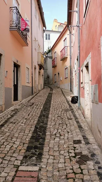 A narrow alley in Lisbon where people walk. High quality photo