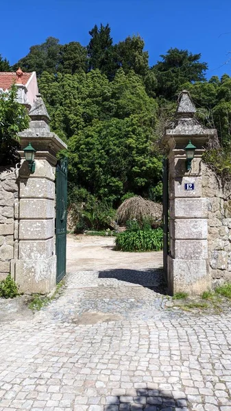 Stone pillars and a stone fence with iron gates. Entrance to the territory. High quality photo