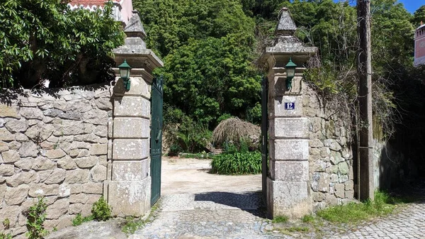 Stone pillars and a stone fence with iron gates. Entrance to the territory. High quality photo