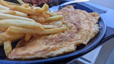 Siyah tabakta çırpılmış yumurta ve patates kızartması. Yüksek kalite fotoğraf