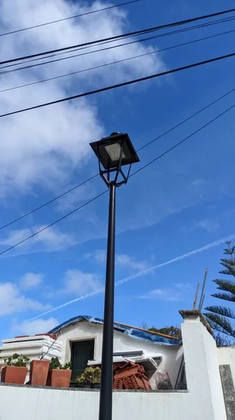 白い石の柵の近くには青い空と雲の背景を背景にした高い通りのランプポストがありますシントラリスボンポルトガルの通りを照らすためにランタンでランプポスト — ストック写真