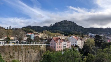 Dağlar, orman ve şehir mavi gökyüzüne karşı her zaman çok turistin olduğu bir yerde. İskoçya, evler, yayalar, mavi gökyüzü, Sintra 'nın turistik bölgesinde büyük bir park.