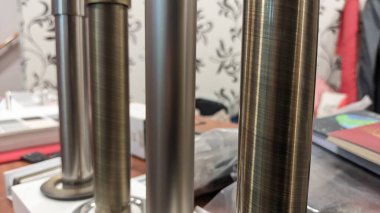 Örnek olarak atölyedeki masanın üzerinde çeşitli metal kornişler duruyor.