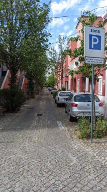 24.03.2023 Portekiz tarzı güzel bir sokak granit kaldırım taşları ve park edilmiş arabaların fotoğrafı.