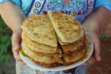 Büyükannem elinde sıcak ev yapımı plasentler tutuyordu. Geleneksel bir Moldova yemeği fotoğrafı.